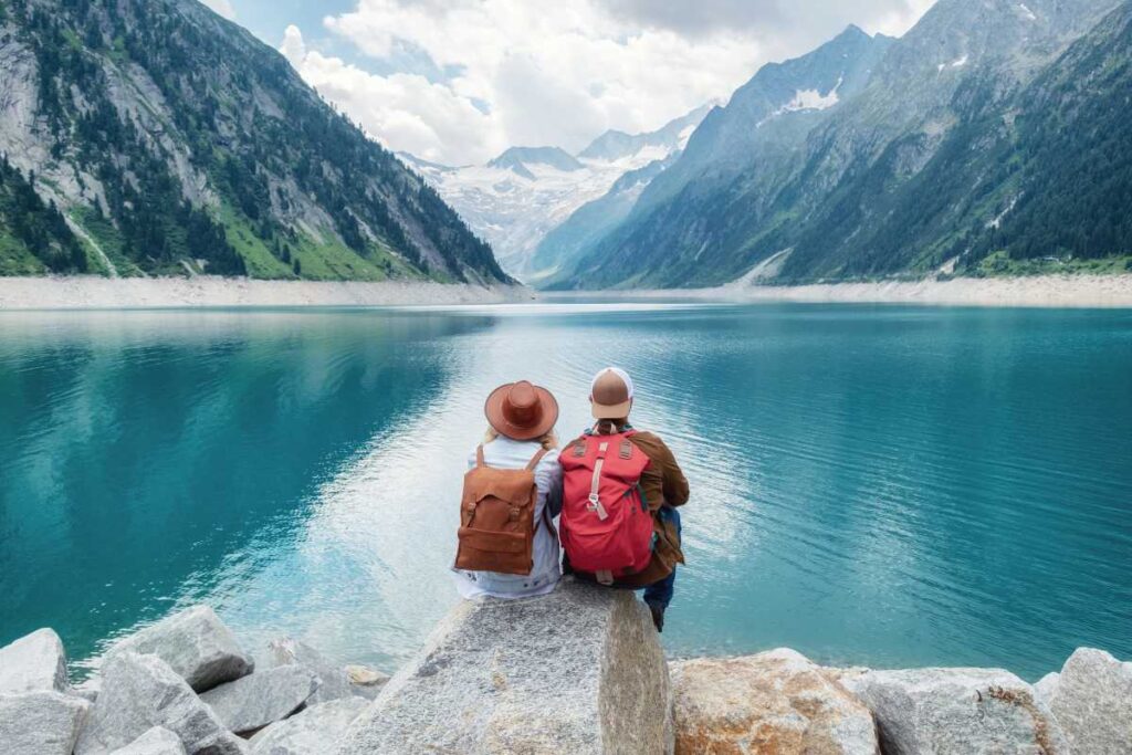 Ett par beundrar utsikten över en spegelblank sjö