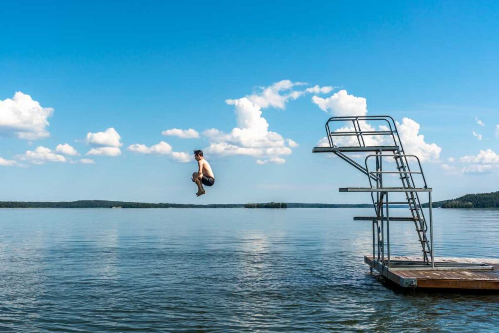 Man som hoppar från en trampolin ner i en sjö